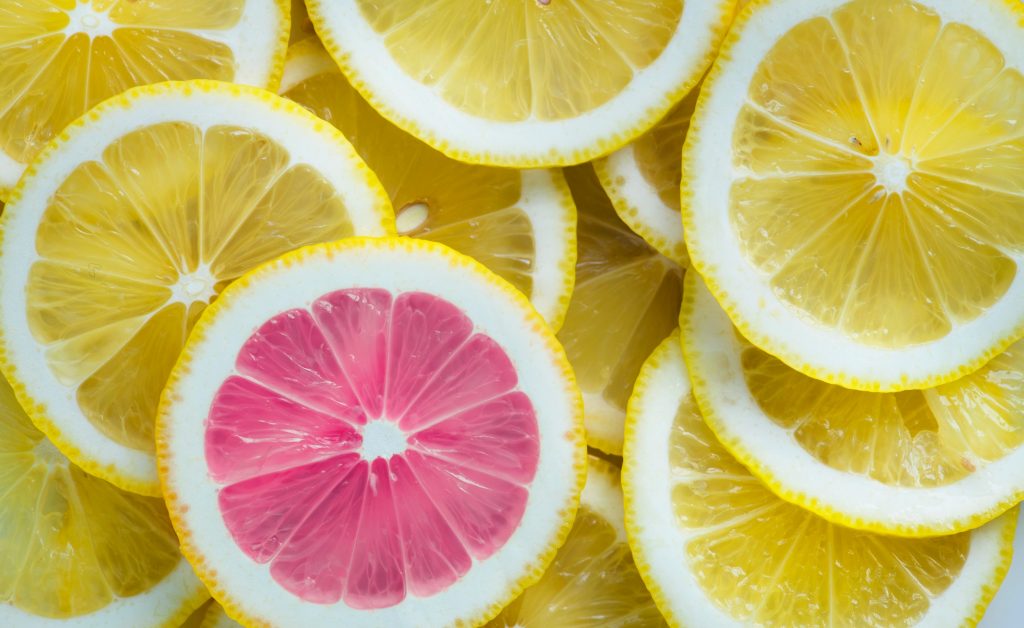 Sliced yellow lemons with one pink lemon slice